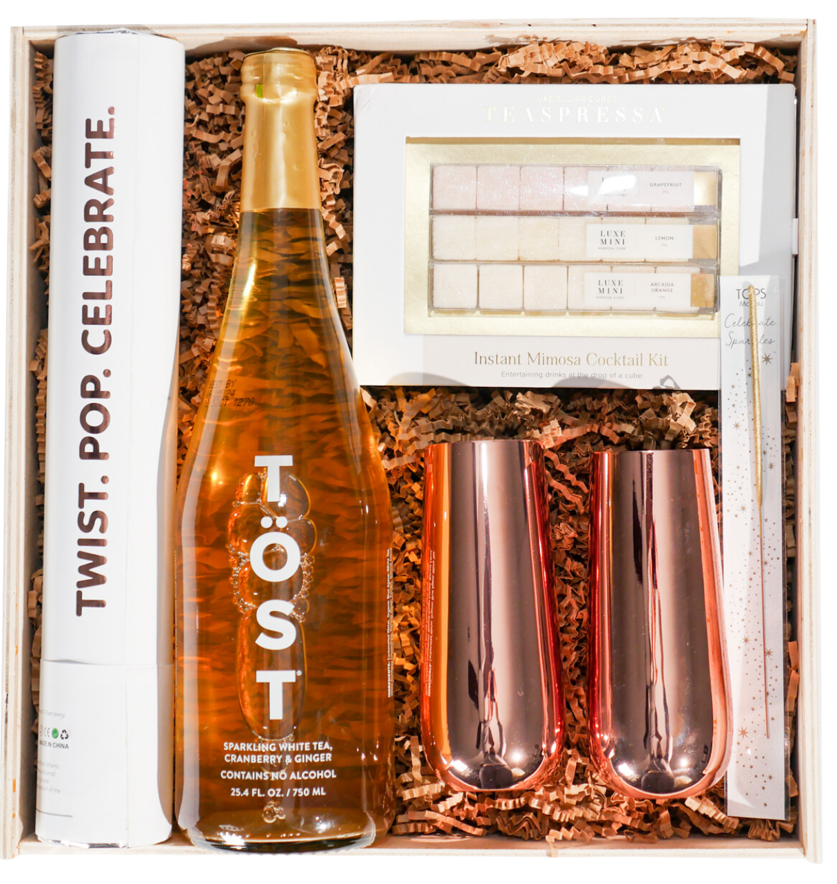 A celebration gift with alcohol-free TÖST sparkling tea, Teaspressa mixer cubes, metallic flutes and party details