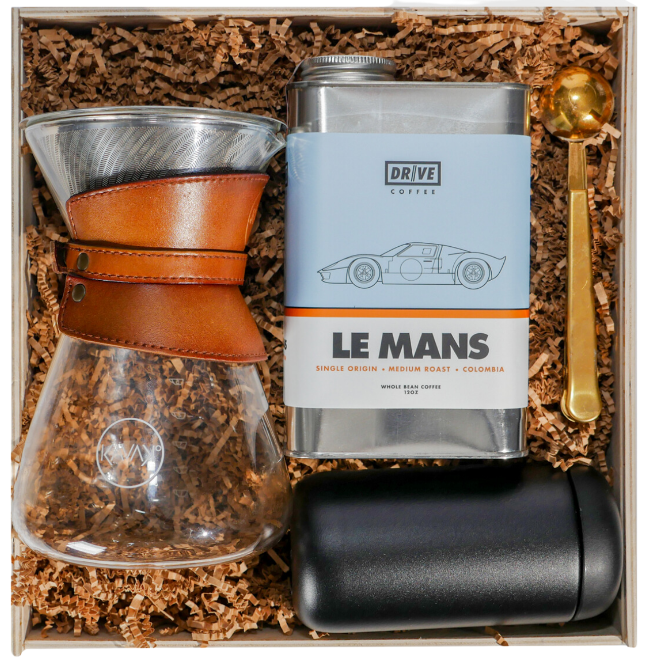 A custom wooden gift box with DRIVE coffee, a pour-over brewer, a black tumbler and a gold coffee scoop