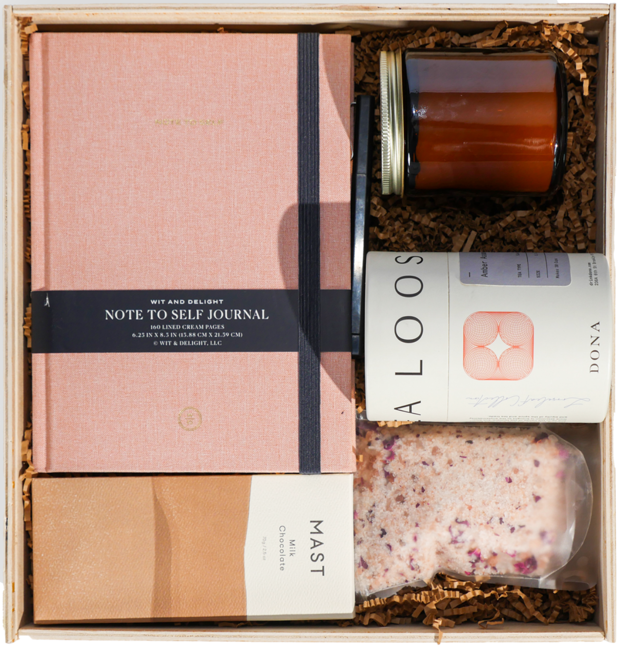 A custom gift with a clothbound journal, Dona tea, Mast chocolate, a candle and bath salts