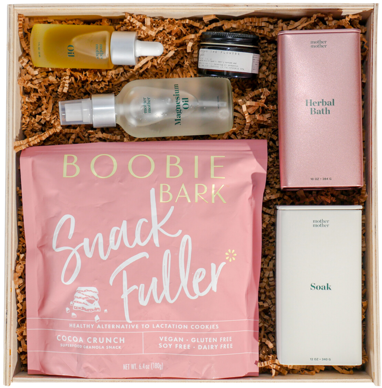 A wooden gift box with Mother Mother bath and body products and a packaged snack